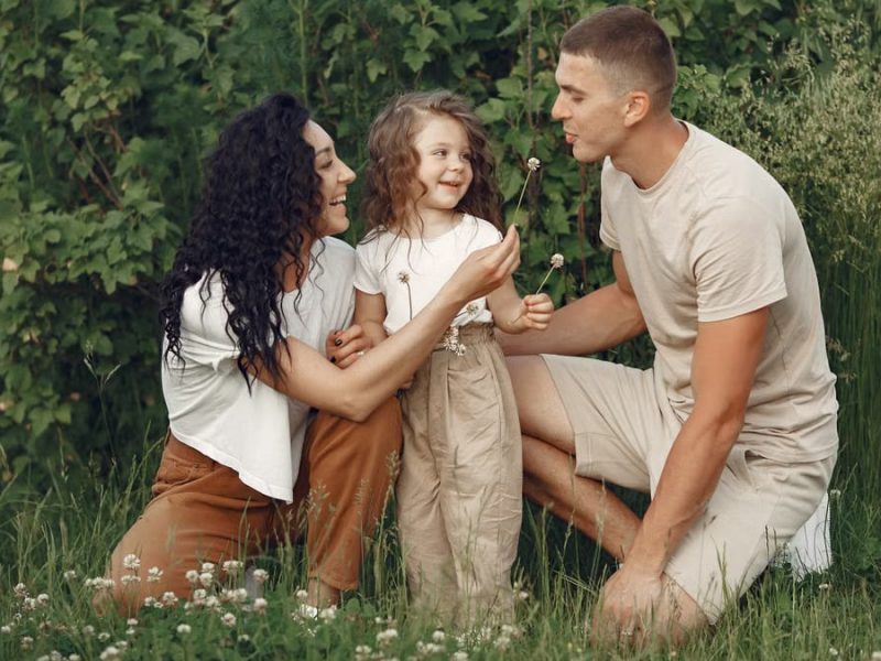 A joyful family enjoying time together in a lush green meadow, capturing love and bonding.